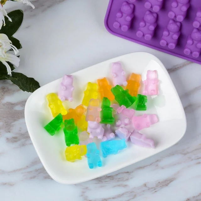 Gummy bears beside the purple bear mold